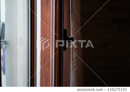 Partially opening a home window on a bright morning, revealing a close-up of the handle and frame, inviting fresh air and new beginnings into the domestic space Partially opening a home window on a bright morning, revealing a close-up of the handle and frame, inviting fresh air and new beginnings into the domestic space 138275335