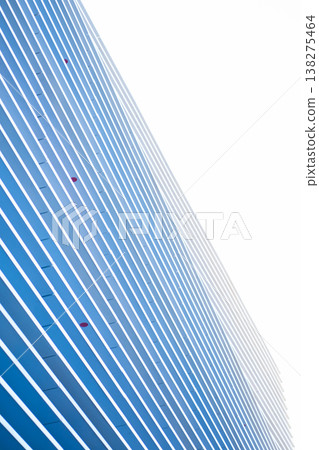 Modern skyscraper facade of blue panels and white diagonal stripes forms a geometric rhythm against clear sky, evoking innovation, growth and contemporary urban design Modern skyscraper facade of blue panels and white diagonal stripes forms a geometric rhythm against clear sky, evoking innovation, growth and contemporary urban design 138275464