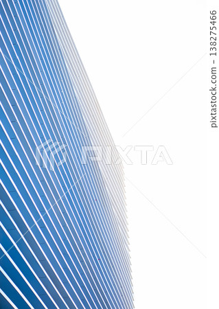 Modern building facade showcasing a repetitive pattern of blue vertical lines against a bright white background, creating an abstract and minimalist architectural design Modern building facade showcasing a repetitive pattern of blue vertical lines against a bright white background, creating an abstract and minimalist architectural design 138275466