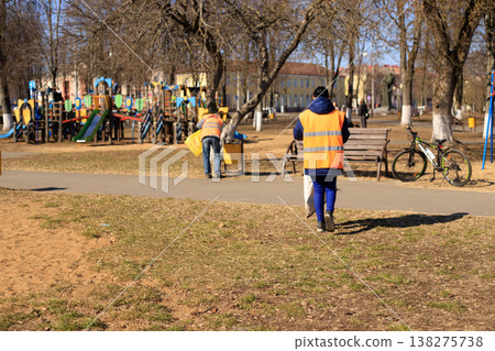 Municipal workers collect trash in a city park collects dust and dirt. Municipal workers collect trash in a city park collects dust and dirt. 138275738