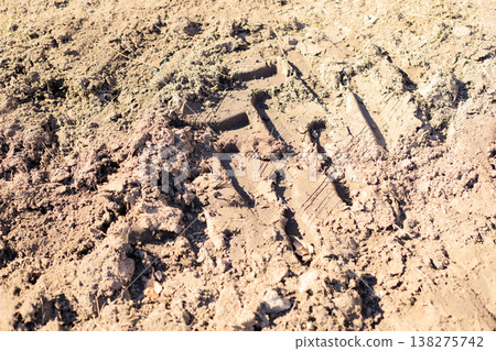 Traction marks from tractor and construction equipment on wet sandy soil. Traction marks from tractor and construction equipment on wet sandy soil. 138275742