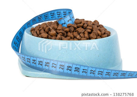 Dry pet food in bowl with measuring tape portion control concept Dry pet food in bowl with measuring tape portion control concept 138275768