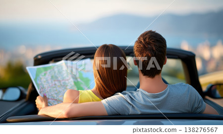 Happy young couple sitting in convertible car holding map planning road trip route 138276567