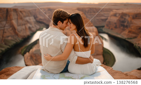 Romantic couple sitting on red rock cliff hugging during sunset view over river canyon landscape 138276568