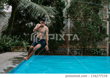 Man enjoying refreshing swim in outdoor pool Man enjoying refreshing swim in outdoor pool 138277538