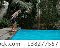 Southeast Asian man jumping into pool creating splash 138277557