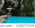 Man diving into swimming pool on a sunny day 138277559