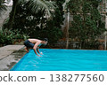Southeast Asian man enjoying water splash in pool 138277560