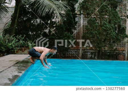 Southeast Asian man enjoying water splash in pool Southeast Asian man enjoying water splash in pool 138277560