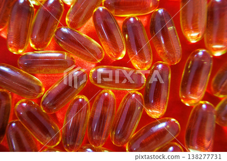 Top view of fish oil capsules on red background forming a bright pattern. Omega 3 supplements and healthcare concept. 138277731
