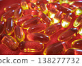 Close up of fish oil capsules scattered on red fabric. Omega 3 supplements, healthy lifestyle and nutrition concept with bright glossy softgel pills. 138277732