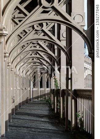 In a sweeping display of 19th-century elegance, the bridge's skeletal arches form a vaulted promenade that stretches toward the horizon. The play of afternoon light filters through the rhythmic iron 138277848