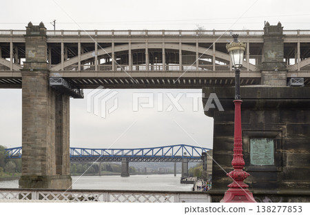 A striking dialogue between eras, this scene showcases the High Level Bridge as a monumental testament to Victorian ingenuity. Through its iron arches, the cobalt-blue Queen Elizabeth II Metro Bridge 138277853