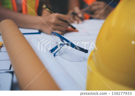 engineer and an architect reviewing blueprints and construction plans together at a bustling construction site engineer and an architect reviewing blueprints and construction plans together at a bustling construction site 138277933