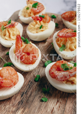 Boiled eggs stuffed with yolk and seasoned with mayonnaise, stuffed eggs with shrimp, on a wooden chopping board, selective focus, close-up, no people, Boiled eggs stuffed with yolk and seasoned with mayonnaise, stuffed eggs with shrimp, on a wooden chopping board, selective focus, close-up, no people, 138278922