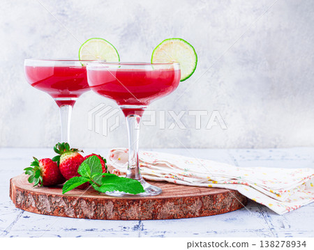 Refreshing cocktail in an elegant glass with lime and strawberries, sunshine, no people, Refreshing cocktail in an elegant glass with lime and strawberries, sunshine, no people, 138278934