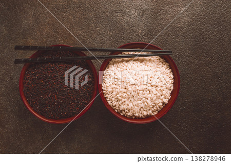 Two clay bowls of black and white rice, with chopsticks, top view, no people Two clay bowls of black and white rice, with chopsticks, top view, no people 138278946