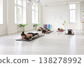 Yoga class practicing chaturanga in minimalist studio, group women aligned on mats 138278992