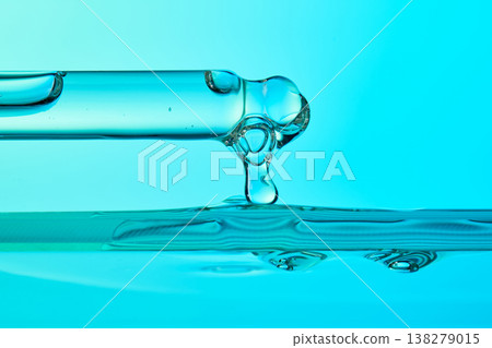 Pipette dripping transparent serum onto turquoise liquid surface Pipette dripping transparent serum onto turquoise liquid surface 138279015