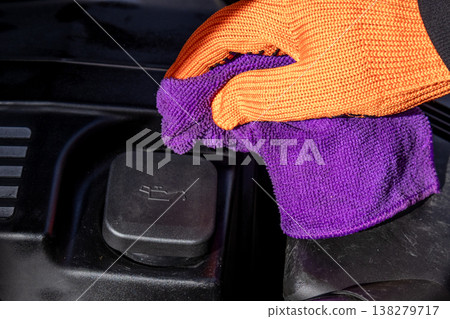 A dedicated mechanic expertly wipes down the engine, ensuring every detail shines bright in a lively garage setting A dedicated mechanic expertly wipes down the engine, ensuring every detail shines bright in a lively garage setting 138279717