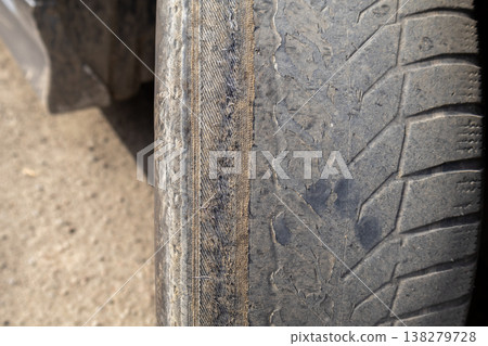 Cleaning the wheel of a car reveals details of dirt and wear while ensuring better handling and safety on the road during a bright day outdoors Cleaning the wheel of a car reveals details of dirt and wear while ensuring better handling and safety on the road during a bright day outdoors 138279728