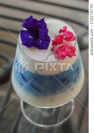 closeup butterfly pea milk decorated with purple butterfly pea flowers and a red flowers branch in a clear glass placed on wooden tray on a blue cloth, blur nature background, drink, food, health, closeup butterfly pea milk decorated with purple butterfly pea flowers and a red flowers branch in a clear glass placed on wooden tray on a blue cloth, blur nature background, drink, food, health, 138279739