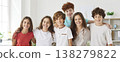Cheerful school children gathering closely for group photo, hugging, smiling and posing together. 138279822