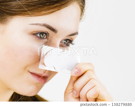Woman applying pore strips on nose Woman applying pore strips on nose 138279880