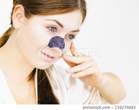 Woman applying pore strips on nose 138279883