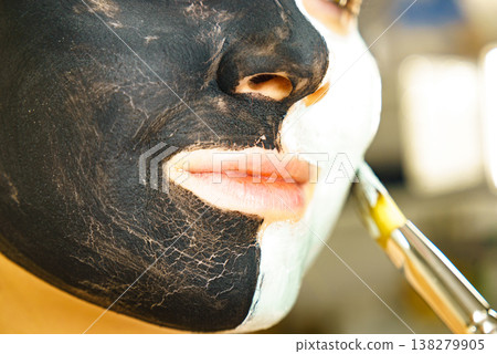 Girl black and green mud mask on face Girl black and green mud mask on face 138279905
