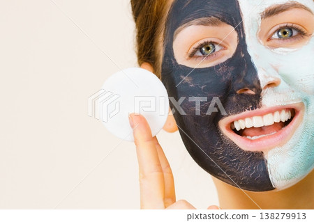 Girl remove black white mud mask from face Girl remove black white mud mask from face 138279913