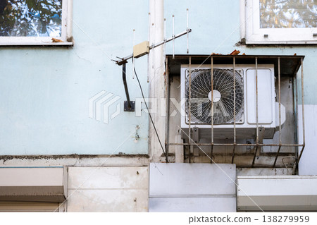 air conditioner is installed on facade of the building. air conditioner compressor is on wall. air conditioner is installed on facade of the building. air conditioner compressor is on wall. 138279959