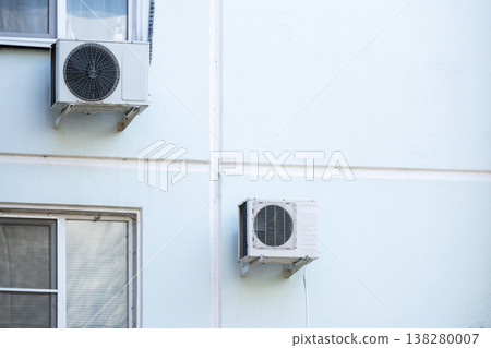 air conditioner is installed on facade of the building. air conditioner compressor is on wall. air conditioner is installed on facade of the building. air conditioner compressor is on wall. 138280007