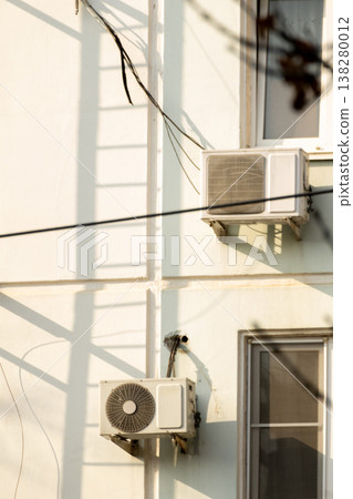 air conditioner is installed on facade of the building. air conditioner compressor is on wall. air conditioner is installed on facade of the building. air conditioner compressor is on wall. 138280012