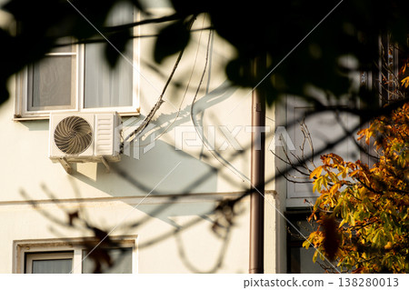 air conditioner is installed on facade of the building. air conditioner compressor is on wall. air conditioner is installed on facade of the building. air conditioner compressor is on wall. 138280013