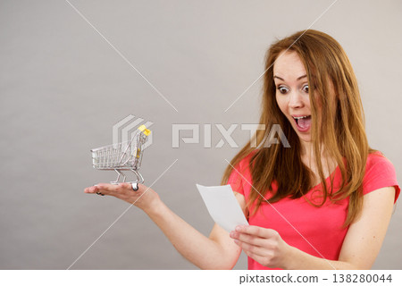 Woman with bill and shopping cart 138280044