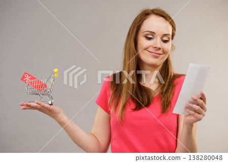 Woman with bill and shopping cart 138280048
