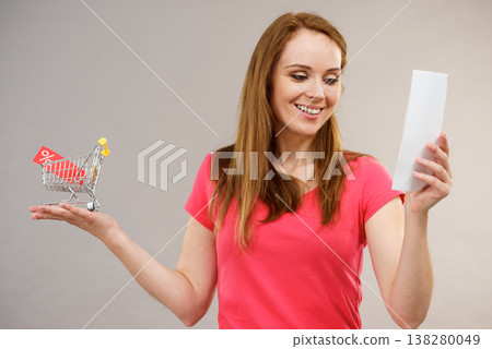Woman with bill and shopping cart 138280049