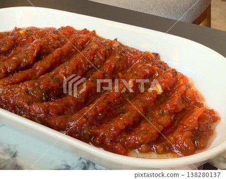 Spicy Turkish ezme spread served in a white dish with rich red pepper and tomato texture. Traditional meze appetizer, restaurant menu presentation and savory condiment for grilled dishes Spicy Turkish ezme spread served in a white dish with rich red pepper and tomato texture. Traditional meze appetizer, restaurant menu presentation and savory condiment for grilled dishes 138280137