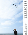 A man on the seashore watches birds fly away 138280138