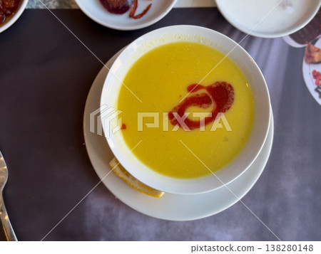 Creamy lentil soup served with paprika butter swirl and lemon on a white plate. Traditional Turkish comfort food, restaurant starter presentation and warm nourishing meal concept 138280148