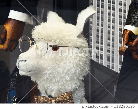 Plush llama in round glasses and glitter bow tie posed in a stylish shop window. Whimsical visual merchandising, quirky fashion display and playful retail character for urban storefront branding Plush llama in round glasses and glitter bow tie posed in a stylish shop window. Whimsical visual merchandising, quirky fashion display and playful retail character for urban storefront branding 138280156