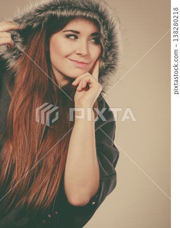 Happy woman wearing dark poncho coat with hood Happy woman wearing dark poncho coat with hood 138280218