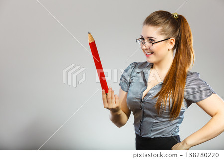 Teacher looking elegant woman holding big pencil Teacher looking elegant woman holding big pencil 138280220