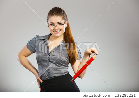 Teacher looking elegant woman holding big pencil Teacher looking elegant woman holding big pencil 138280221