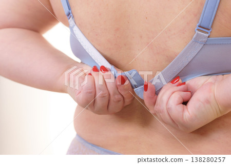Woman back view putting on her bra lingerie. 138280257