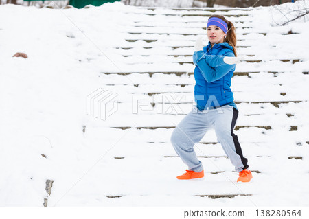 Woman wearing sportswear exercising outside during winter 138280564