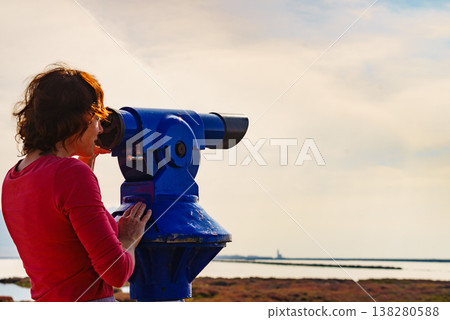 Woman using tourist binoculars, Cabo de Gata, Spain 138280588
