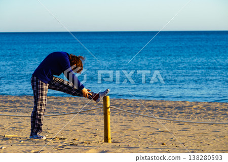 Woman exercising on beach at morning. Woman exercising on beach at morning. 138280593