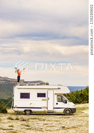 Woman traveling with caravan, taking photo from rv roof 138280602